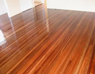 After: High-gloss polished timber floor after professional sanding and finishing