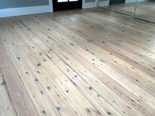 Whitewashed timber floor beside a mirrored built-in wardrobe