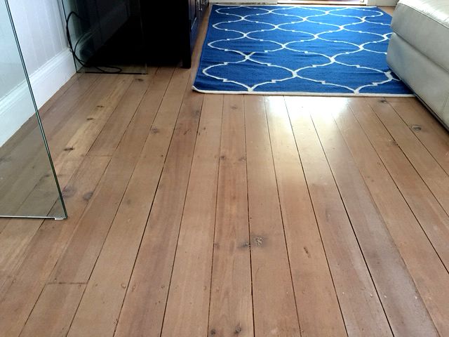 Whitewashed timber floor in a living room with a patterned rug